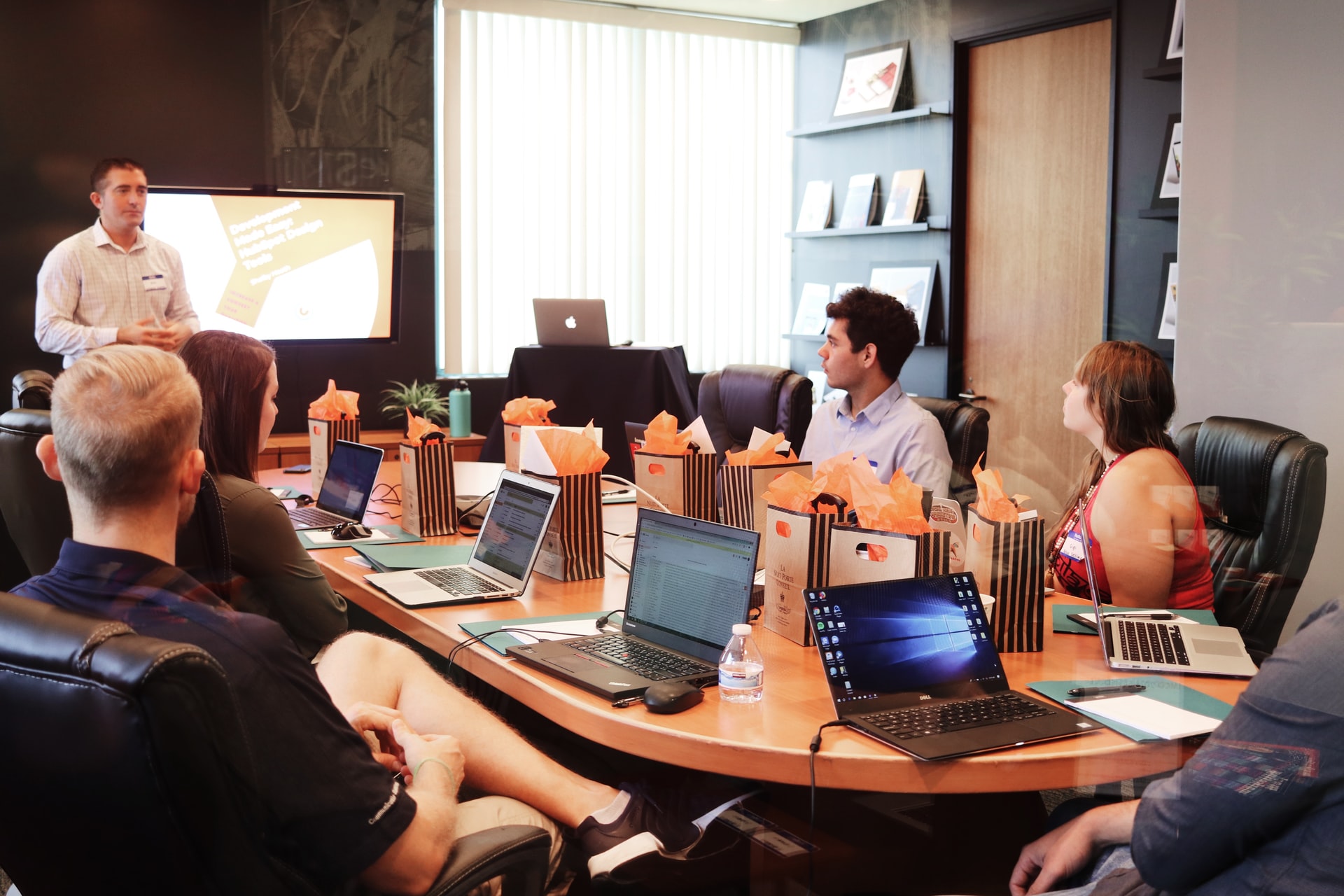 A team at an office discussing technology expense management software during a meeting