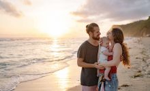 A young family, man and woman and child, at the beach.