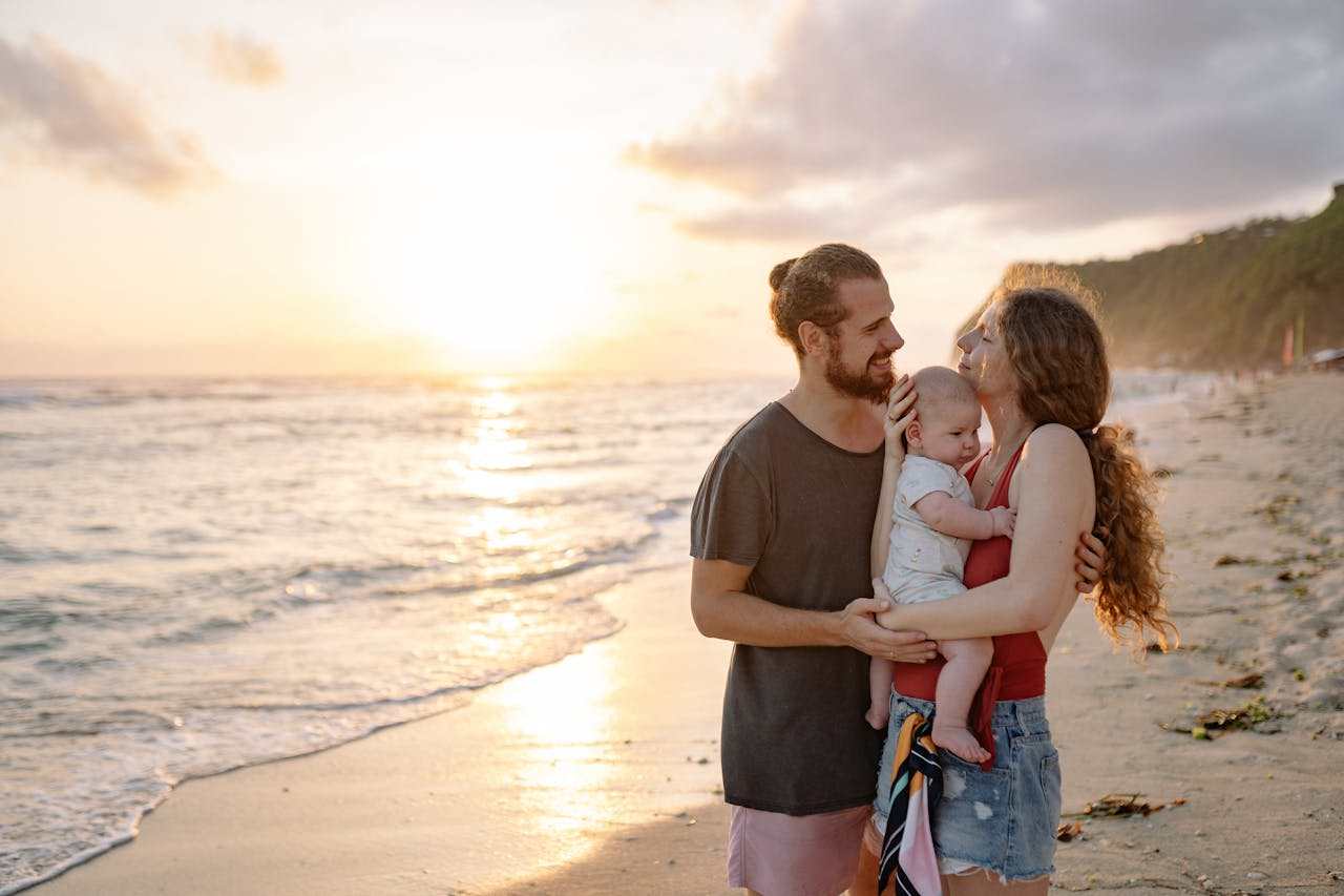 A young family, man and woman and child, at the beach.