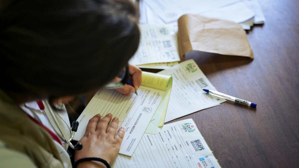 A-doctor-fills-out-medical-forms-indoors--focusing-on-patien1.jpg