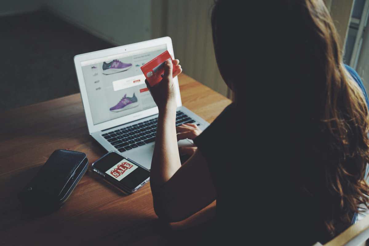 A-woman-shops-online-using-a-laptop-and-credit-card-on-a-woo1.jpg