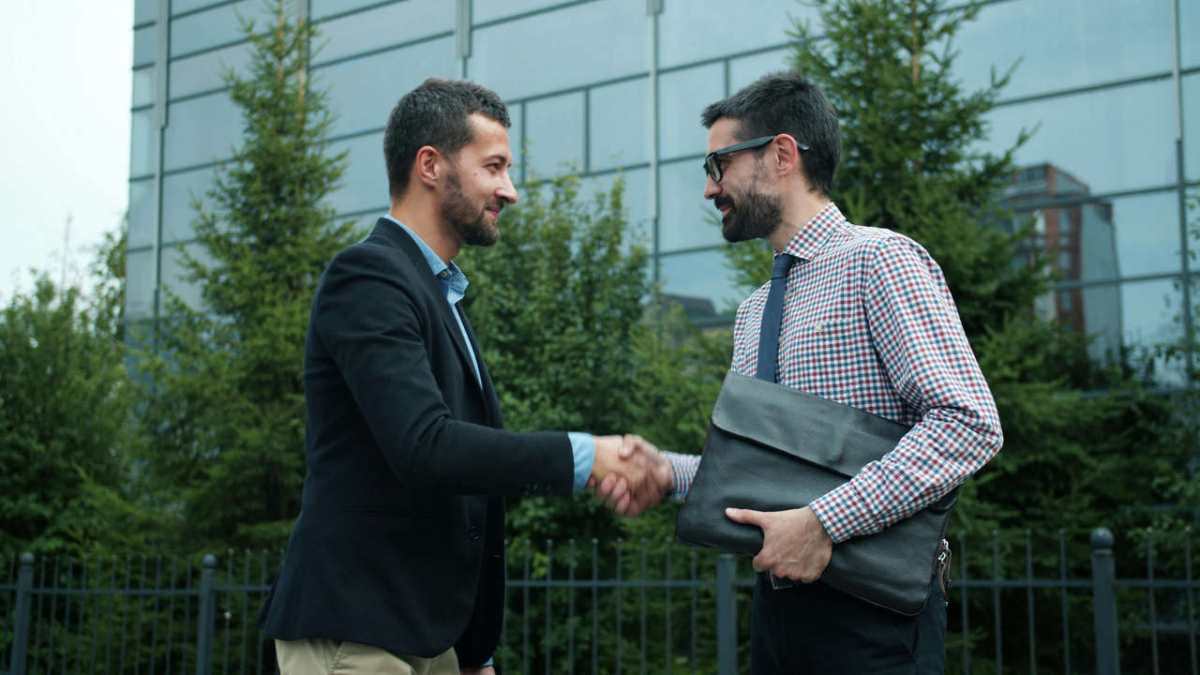 Two-businessmen-shaking-hands-outside-a-modern-office-buildi1.jpg
