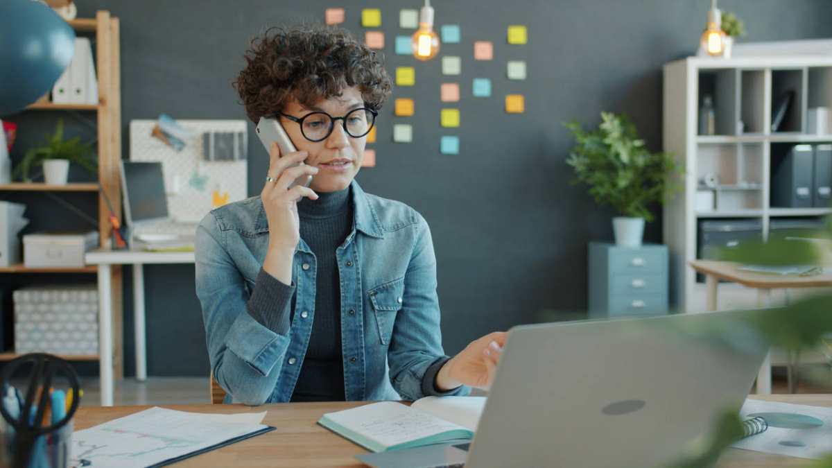 Woman-talking-on-phone-at-desk-with-laptop1.jpg