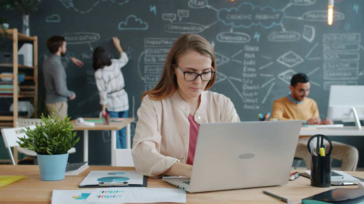 Woman-working-on-laptop-in-busy-modern-office.jpg
