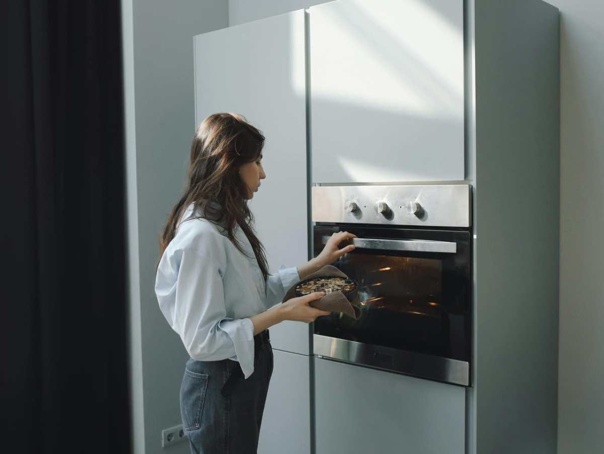 Young-woman-baking-at-home--placing-a-dish-in-the-oven--Brig1.jpg
