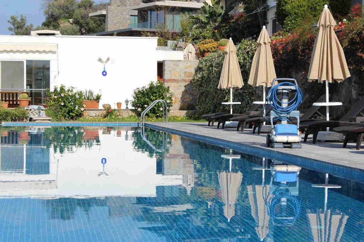 Relax by the serene poolside with lounge chairs and umbrellas at a modern resort.