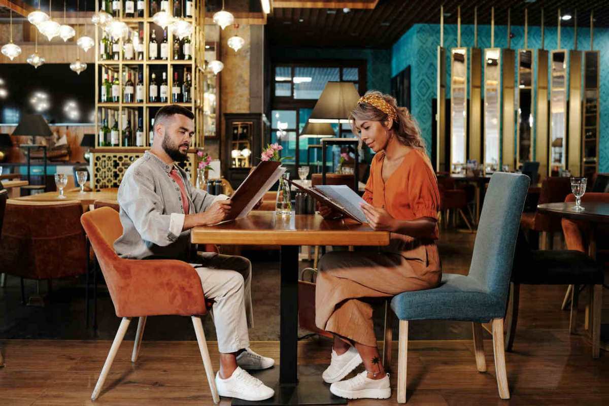Couple sitting together at a stylish restaurant reviewing the menu, creating a warm and inviting atmosphere.