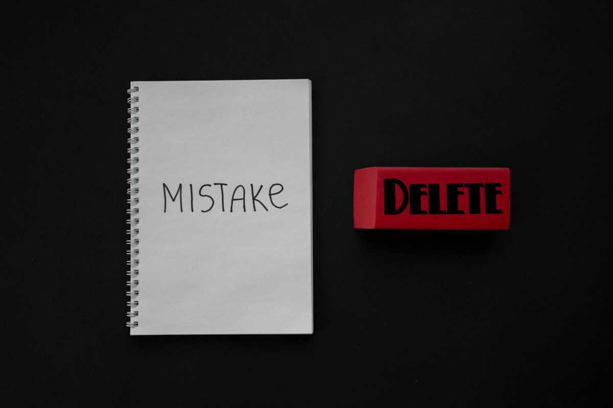 Notebook labeled 'Mistake' next to a red delete eraser on a dark background.