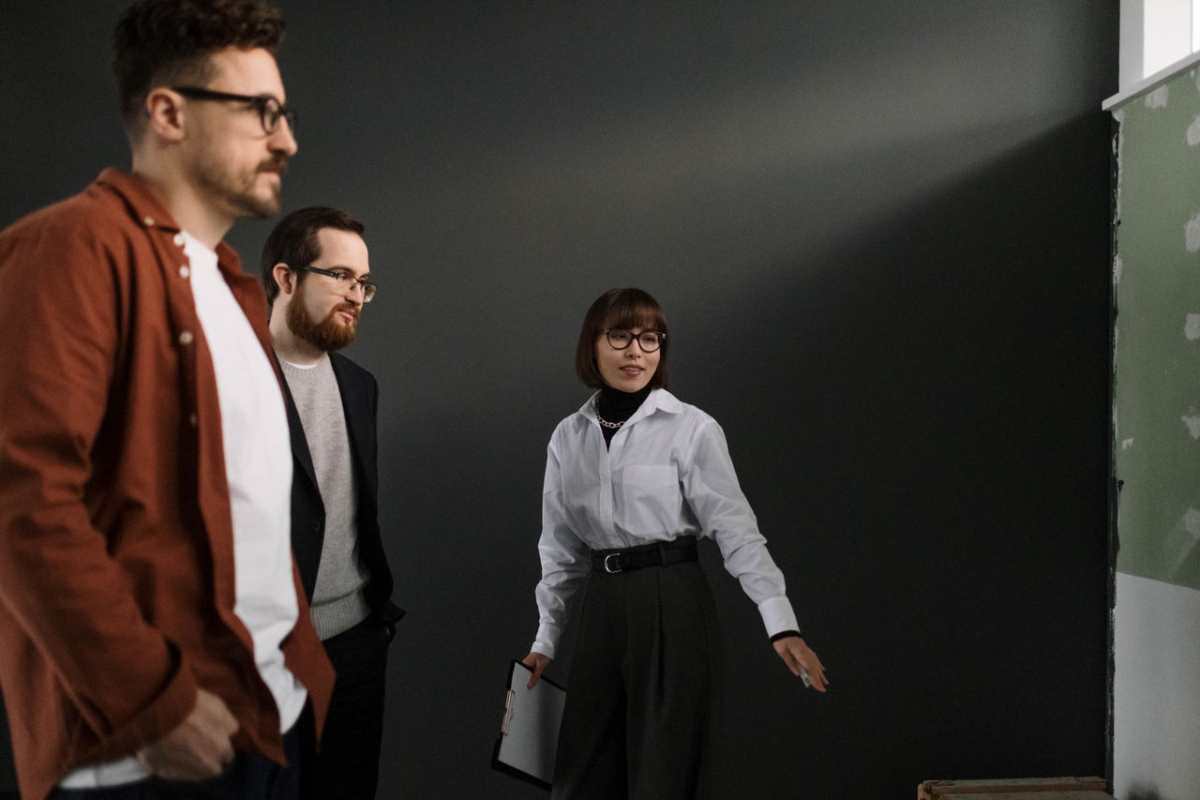 Three colleagues in a studio having a professional discussion. Smart casual attire.