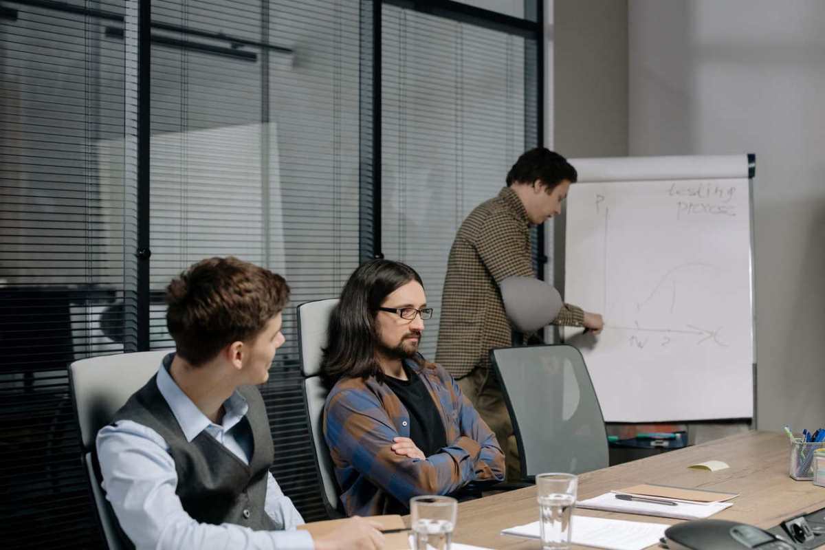 Team members discussing project strategy during an office meeting with charts and notes.