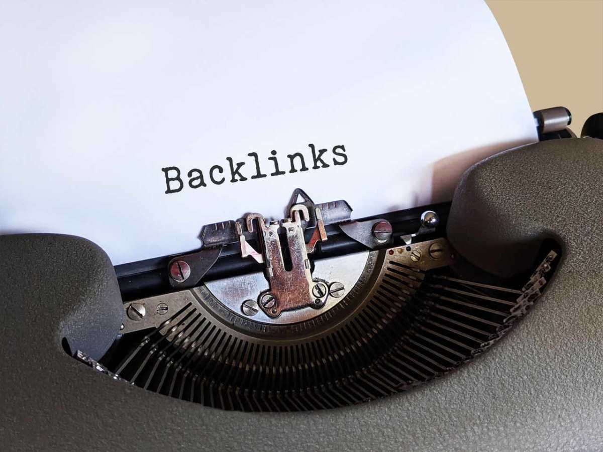 Close-up of a vintage typewriter printing the word 'Backlinks,' emphasizing content and SEO concepts.