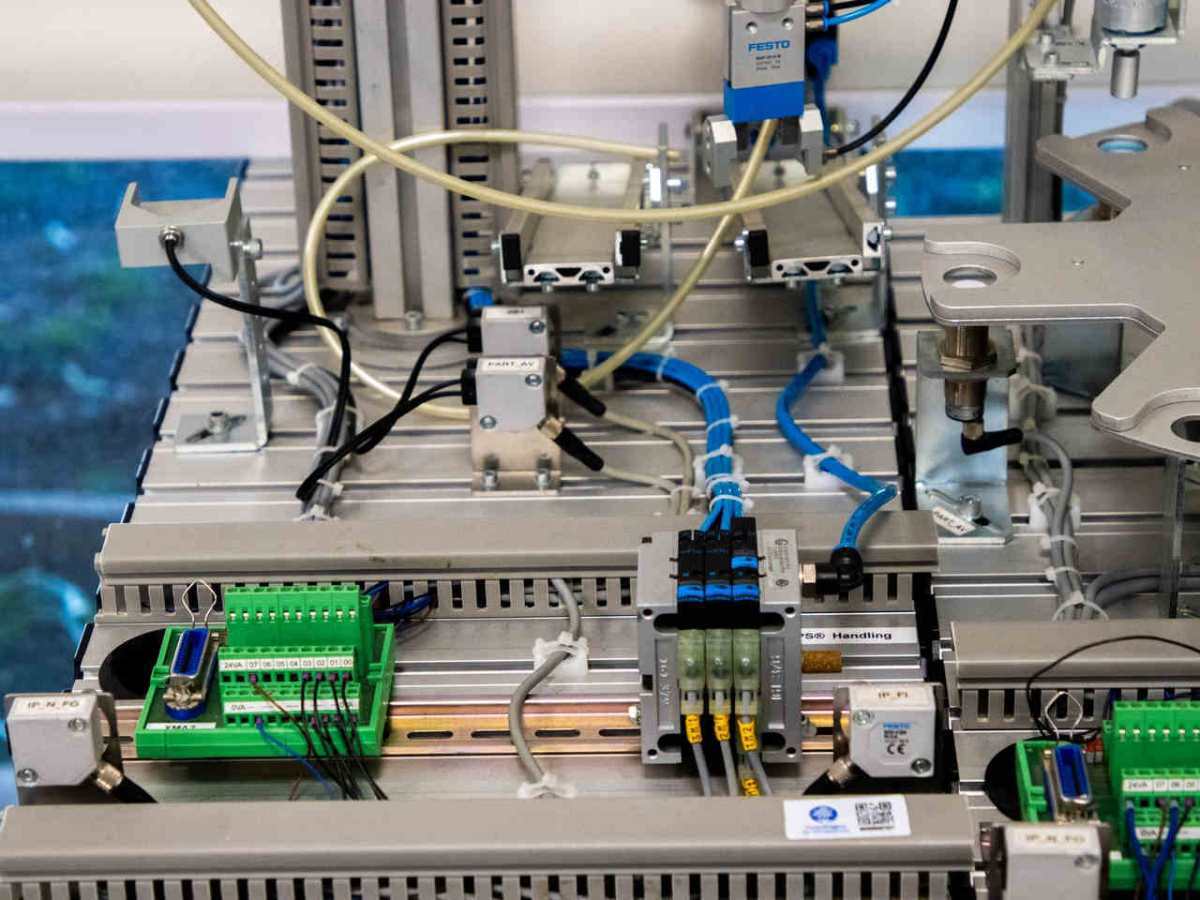 Close-up of industrial equipment showcasing electronic wiring and sensors in a manufacturing setup.