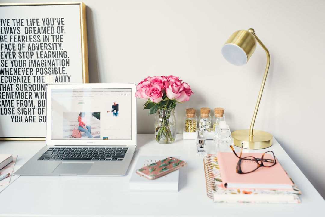 MacBook-Air-beside-gold-colored-study-lamp-and-spiral-books.jpg