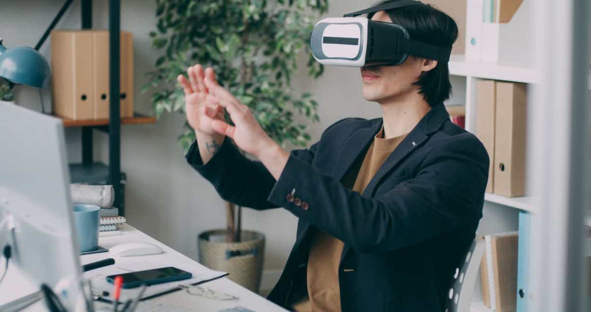 A man in an office environment using a virtual reality headset, engaging with VR content.
