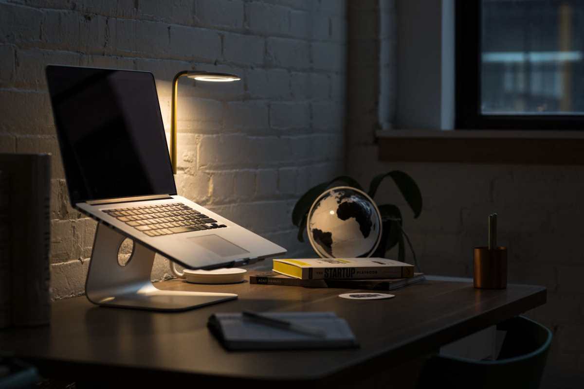 A modern workspace featuring a laptop, books, and ambient lighting for a productive environment.