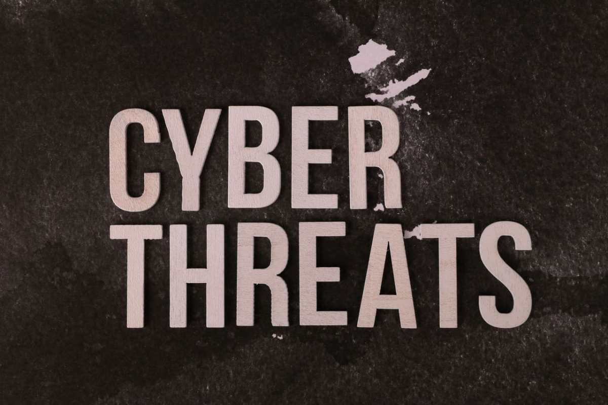 The phrase 'Cyber Threats' displayed on a textured dark background, emphasizing digital security.