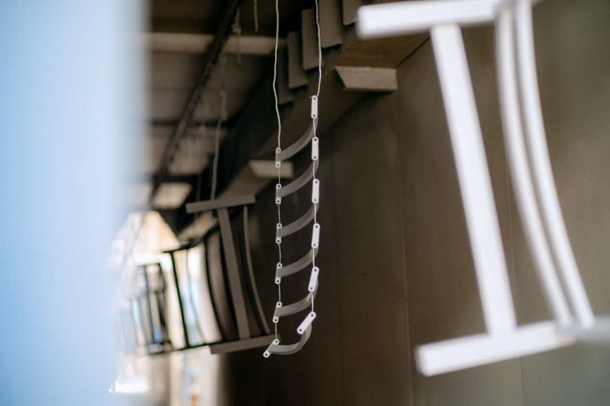 Close-up of industrial metal parts hanging in a coating process, showcasing manufacturing details.