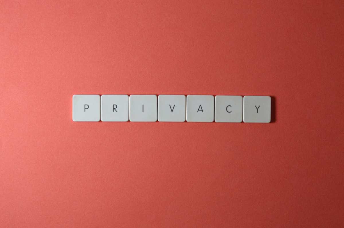 Close-up of letter tiles spelling PRIVACY on a red background, symbolizing data protection.