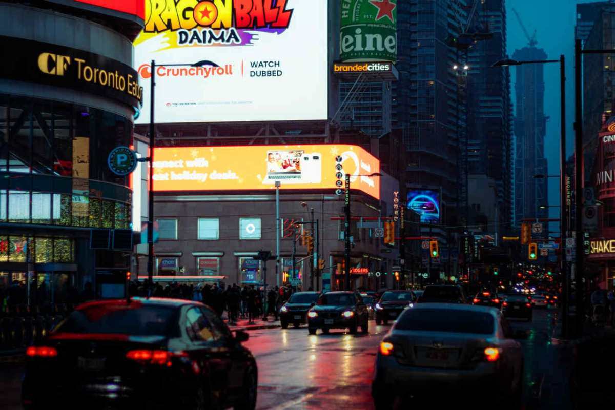Dynamic city street scene in Toronto with vibrant billboards and bustling traffic.