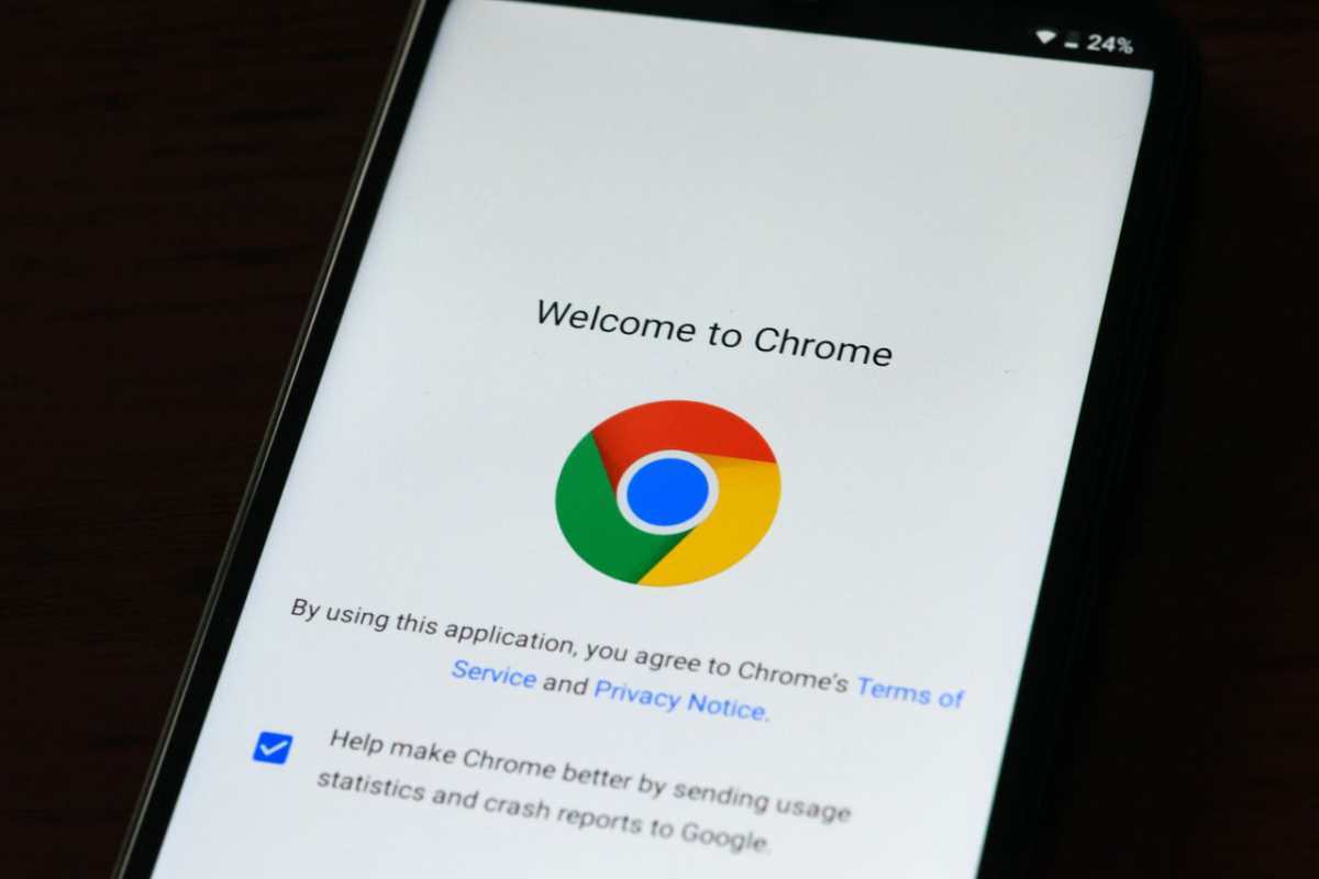 Close-up of smartphone displaying Google Chrome's welcome page and logo.