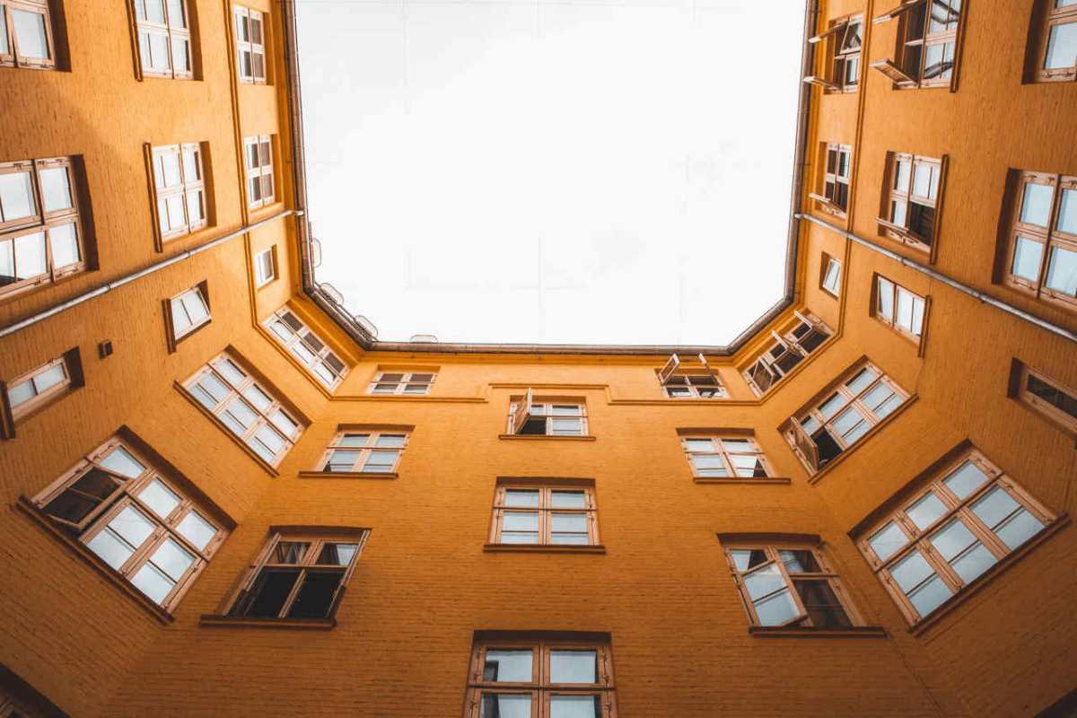 A low angle view of a yellow multi-storey building courtyard in Copenhagen, Denmark.