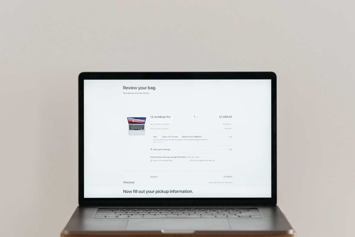 Minimalist laptop showing an online checkout screen on a white background, ideal for tech context.